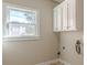 Bright laundry room with white cabinets and tile floor at 4348 Meadow Vista Dr, Stonecrest, GA 30038