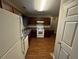 Kitchen with wood cabinets, white appliances, and flooring at 278 Privette Sw Rd, Marietta, GA 30008