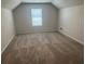 Spacious bonus room with carpeted floor and window with blinds at 27 Longhorn Way, Auburn, GA 30011