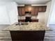 Granite kitchen island with double sink and dark brown cabinets at 1535 Iris Walk, Jonesboro, GA 30238