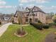 Two-story home with stone and brick exterior, landscaping, and driveway at 3960 Carissa Trce, Cumming, GA 30040