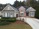 Brick and gray sided two story home with a three car garage and manicured landscaping at 541 Richmond Pl, Loganville, GA 30052