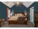 Spacious main bedroom with dark blue walls and a wooden bed frame at 215 Mackenzie Ct, Canton, GA 30115