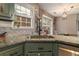 Modern kitchen with granite countertops, stainless steel appliances, and green cabinets at 215 Mackenzie Ct, Canton, GA 30115