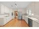 Spacious kitchen featuring white cabinets, stainless steel appliances, and hardwood floors at 5892 Smoke Rise Ct, Stone Mountain, GA 30087