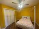 Yellow bedroom with a white four-poster bed, ceiling fan, and hardwood-style floors at 2594 Boulder Springs Pt, Ellenwood, GA 30294