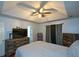 Main bedroom with ceiling fan, hardwood floors and large TV at 1712 Graystone Dr, Hampton, GA 30228