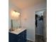 Bathroom with blue vanity, granite countertop, and walk-in closet at 1712 Graystone Dr, Hampton, GA 30228