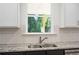 Kitchen sink with granite countertop and white subway tile backsplash at 2126 Seavey Dr, Decatur, GA 30032