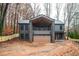 Front view of a modern two-story house with a wooden garage door, stone accents, and a covered balcony at 600 Jones Rd, Roswell, GA 30075