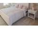 Bright bedroom with a bed, nightstand, and floral bedding at 573 Auburn Crossing Dr, Auburn, GA 30011
