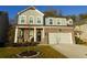 Two-story home with brick and siding, a two-car garage, and a landscaped front yard at 573 Auburn Crossing Dr, Auburn, GA 30011