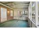 Empty screened porch with green carpeting and ceiling fan at 1018 Duke Se Dr, Conyers, GA 30013