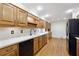 Modern kitchen with wood cabinets, black appliances, and hardwood floors at 5417 Trentham Dr, Dunwoody, GA 30338