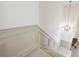 Elegant staircase with wainscoting and a modern light fixture at 5417 Trentham Dr, Dunwoody, GA 30338