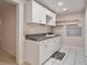 Basement kitchen with white cabinets, dark countertop, and tile floor at 9140 N Links Dr, Covington, GA 30014