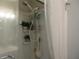 Shower with tiled walls, curtain, and storage at 1318 Shoreham Dr, Atlanta, GA 30349