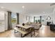 Open concept dining area features a light gray table with bench seating, hardwood floors and natural light at 479 Village Ln, Fairburn, GA 30213