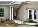 Front entrance with a black door, white columns, and brick facade at 479 Village Ln, Fairburn, GA 30213