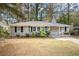 Newly painted gray brick ranch home with a red door and landscaped lawn at 2435 Wood Valley Dr, Atlanta, GA 30344