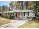 Gray brick ranch home with red door, updated landscaping and driveway at 2435 Wood Valley Dr, Atlanta, GA 30344