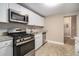Modern kitchen with white cabinets, granite countertops, and stainless steel appliances at 1870 S Columbia Pl, Decatur, GA 30032