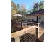 Large wooden deck with railing, grill, patio furniture, and wooded view at 6340 Koweta Rd, Fairburn, GA 30213