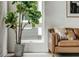 Cozy corner with a large fiddle leaf fig and a brown leather sofa at 1641 Mcnaught Dr # 35, Atlanta, GA 30317