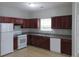 Kitchen with dark wood cabinets, white appliances, and tile floor at 6511 Grey Fox Way, Riverdale, GA 30296