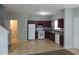 Galley kitchen with dark wood cabinets, white appliances, and tile floor at 6511 Grey Fox Way, Riverdale, GA 30296