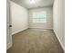 Well-lit bedroom with neutral carpeting and a large window at 3781 Heirloom Loop Ct, Buford, GA 30519