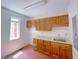 Laundry room with wood cabinets and terracotta tile floor at 1171 Rocky Creek Rd, Locust Grove, GA 30248