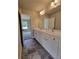 Bathroom with double sinks, white cabinets, and dark grey tile floors at 1117 Kingston Hill Dr, Loganville, GA 30052