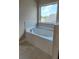 Bathroom with garden tub and window, showcasing natural light at 1117 Kingston Hill Dr, Loganville, GA 30052