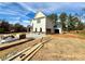 Two-story house with light-colored siding, a detached garage, and unfinished landscaping at 3603 Squires Park Ln, Loganville, GA 30052