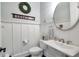 Stylish powder room with white vanity, decorative mirror, and shiplap walls at 4125 Baxter Walk, Cumming, GA 30040