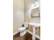 Small powder room with pedestal sink, toilet, and dark hardwood floor at 226 Mclaren Gates Dr, Marietta, GA 30060