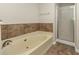 Bathroom with a tub, shower, and updated tile flooring at 4027 Evelyn Dr, Powder Springs, GA 30127