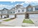 Townhouses with stone and siding, garages, and landscaping under a blue sky at 3848 Pressley Ln # 26, Powder Springs, GA 30127