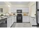 Modern kitchen with white cabinets, black appliances, and granite countertops at 3298 Sheffield Cir, Decatur, GA 30032