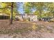 View of house from the backyard, showcasing a deck and mature trees at 3730 Douglas Ridge Trl, Douglasville, GA 30135