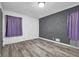 Spacious bedroom with grey accent wall, hardwood floors and ample natural light at 2611 Kings Cir, Lawrenceville, GA 30044