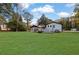 Spacious backyard with large grassy area, detached structure, and fenced dog run at 2611 Kings Cir, Lawrenceville, GA 30044
