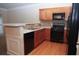 Modern kitchen with wood cabinets, black appliances, and tile backsplash at 832 Arbor Gate Ln # 832, Lawrenceville, GA 30044