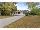White ranch home with a long driveway and mature trees at 200 Sunrise Cir, Riverdale, GA 30274