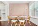 Elegant dining area with a blush-colored accent wall and modern table at 4429 Newfangle Rd, Stone Mountain, GA 30083