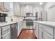 Modern kitchen with gray cabinets, stainless steel appliances, and an island at 4429 Newfangle Rd, Stone Mountain, GA 30083