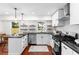 Modern kitchen with white cabinets, herringbone tile backsplash, and black countertops at 2091 East Dr, Decatur, GA 30032