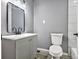 Modern bathroom with gray vanity, a toilet, and a frameless mirror at 1025 Buckhurst Dr, College Park, GA 30349