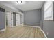 Gray-walled bedroom with wood-look floors and access to other rooms at 1025 Buckhurst Dr, College Park, GA 30349